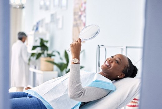 Woman smiling while looking at reflection in mirror