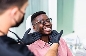 Dentist looking at patient's smile in treatment chair