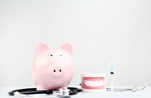 A pink piggy bank set next to a model jaw