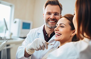 Woman in the dentist’s chair looking at her restored smile