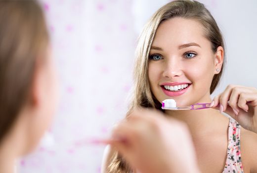 closeup of woman brushing teeth 