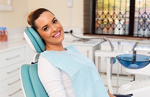 Woman sitting in dental chair and smiling