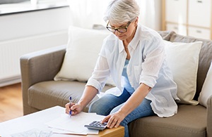 Woman calculating the cost of tooth extractions in Lynchburg