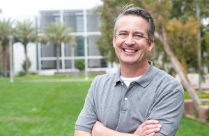 man smiling while standing outside