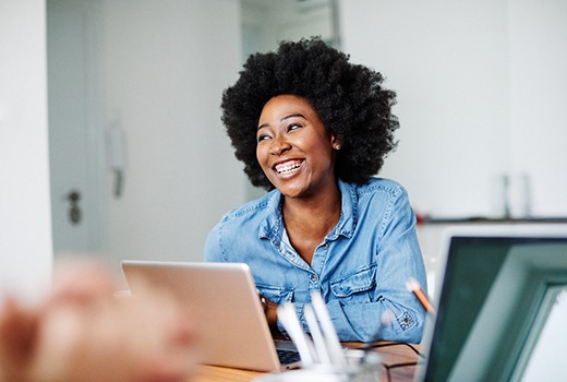 Woman sitting at her desk and smiling