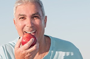 Man smiling and about to eat an apple