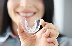 Closeup of patient holding clear mouthguard