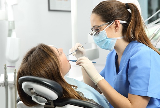 Woman covering her mouth while holding her toothbrush