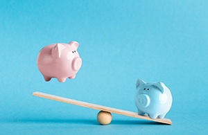 Piggy banks on balance scale