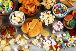 Spread of unhealthy snacks you shouldn't eat after dental implants in Lynchburg