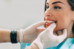 cosmetic dentist examining patient's teeth