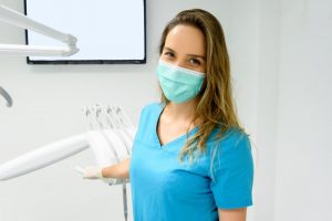 Dental hygienist in mask smiling before appointment