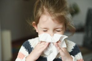 child blowing her nose 